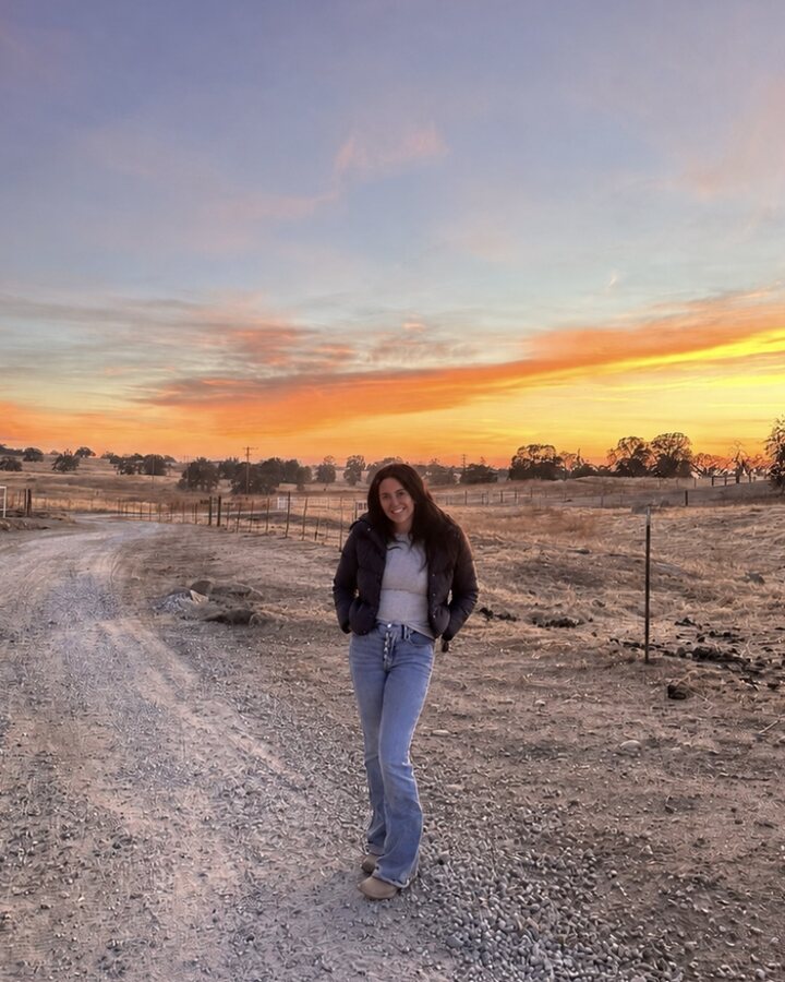 Alexandria Dames, founder of OpenPasture, on the ranch road at sundown